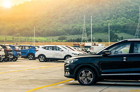 黑色 白色和蓝色的新车停在靠近山的工厂的混凝土停车场 汽车经销商的概念 待售汽车库存 汽车厂停车场 汽车工业概念 汽车出租图片