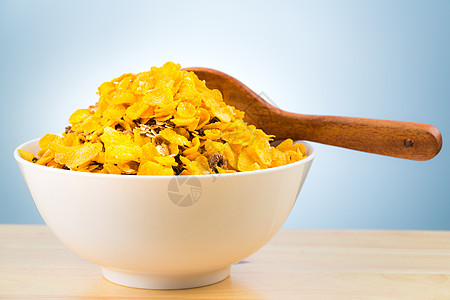 一碗白色的麦片粥 木勺放在木桌上 有复制空间 早上上学前为孩子们准备的早餐 黄色玉米片图片