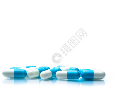 一堆蓝色和白色的胶囊药片在白色背景上被隔离 带有阴影和文本复制空间 全球医疗保健概念预算制药团体疾病生产医院感染抗生素反抗药品图片