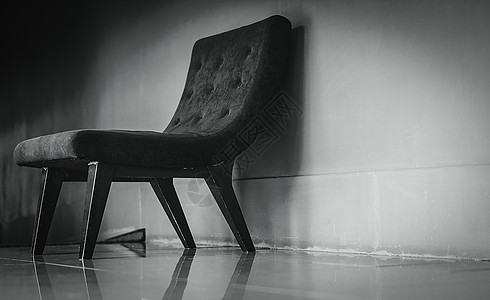 黑色经典椅子 在黑暗和戏剧性的背景下 靠近混凝土墙的空荡荡的休息室里设计独特 沮丧 悲伤和孤独的概念 客厅里有一把空扶手椅 室内图片