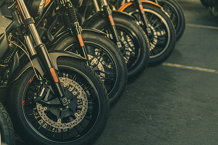 新的摩托车前轮特写镜头 大自行车停在柏油路上 具有运动设计的标志性摩托车 带有独特花纹和辐条轮的黑色轮胎图片