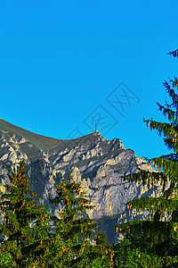 布塞吉山的卡拉曼峰山脉十字悬崖环境英雄岩石顶峰树木山脊枞树图片