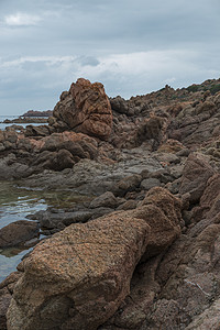 伊索拉罗萨沙地尼亚的岩石蓝色海岸线海景海岸假期胜地旅游悬崖橙色植被图片