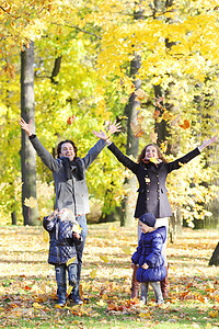 快乐的一家人玩秋假女士女性森林晴天微笑女孩成人父母公园幸福图片