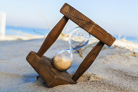 沙漏在海滩上测量小时玻璃海洋天空沙丘滴漏倒数乐器木头图片