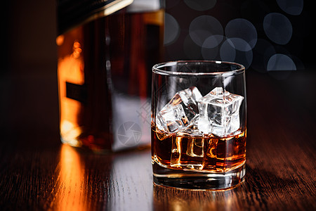 一杯威士忌在石头上 一瓶瓶子在桌子上酒吧酒精食物液体岩石立方体饮料图片