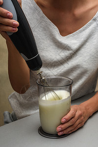 女人在搅拌机里做奶油奶油白色产品玻璃酸奶饮料营养奶制品食物液体杯子图片