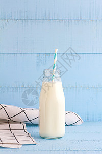 一瓶蓝木本底的牛奶营养奶油早餐白色奶制品桌子玻璃食物瓶子稻草图片