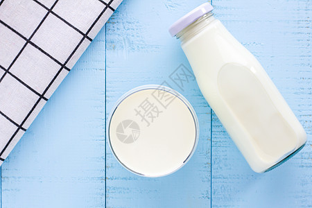 一瓶酒和一杯蓝色木本底的牛奶奶油早餐桌子白色玻璃瓶子奶制品营养食物图片