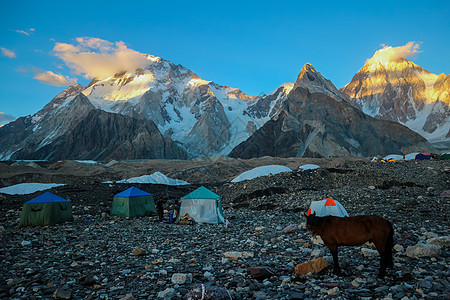 K2和巴基斯坦卡拉科鲁姆山Concordia的宽峰K2和Broad Peak首脑日落崎岖晴天碎石顶峰蓝色风景帐篷冰川图片