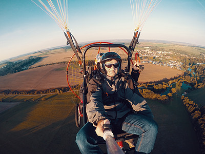 动力滑滑翔式同步飞行螺旋桨航班翅膀冒险风险航空男人降落伞行动头盔图片