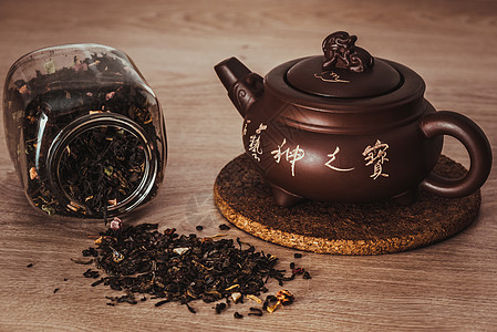 亚洲茶壶在摊台和罐子上撒茶叶的亚洲茶壶仪式食物文化水果软木象形草本植物玻璃营养木头图片