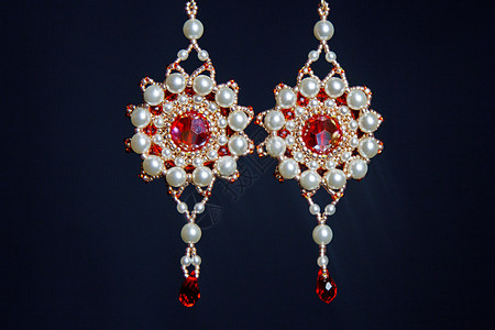 手工制作的饰品由宏中的珠子制成 白色珠子的耳环 石头制成的耳环 漂亮的装饰品 红色珠子的耳环 黑色背景上的装饰品商业风格手镯宝石图片