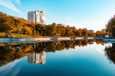 俄罗斯哈巴罗夫斯克Khabarovsk  2018年9月27日 秋季的城市池塘市中心建筑水域摩天大楼旅行地标建筑学森林木头蓝色图片