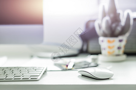 工作桌上有白色键盘和鼠标的计算机桌面技术职场笔记本老鼠阳光小样电脑蓝牙展示扬声器图片