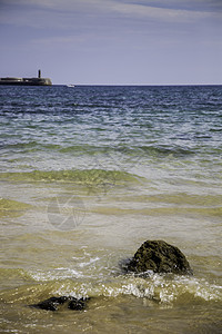 桑迪带石头的海滩海浪太阳日落假期波浪全景天空岩石卵石海洋图片