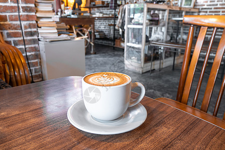 咖啡杯有牛奶和心形 热摩卡咖啡或白杯的卡普奇诺酒 木制桌子上有心脏图案图片