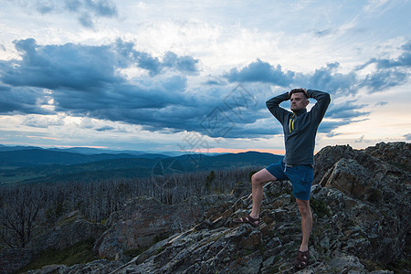 站在悬崖顶上的男人生活顶峰男性冒险石头现实旅游领导游客胜利图片