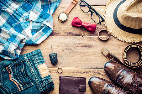 衣服上的素材在木质背景上旅行的服装和配件眼镜商业衣服男人手表牛仔裤帽子正方形棕色男性背景