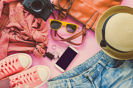 妇女的衣服 放在粉红色地板上腰带衬衫帽子皮革配饰手机要领粉色旅行潮人图片