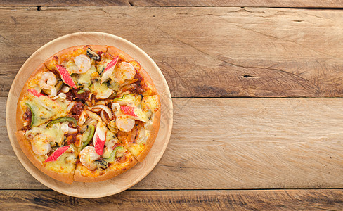 木桌上的比萨海产食品准备吃辣椒火腿食物文化草本植物木板香肠美味烹饪香料图片