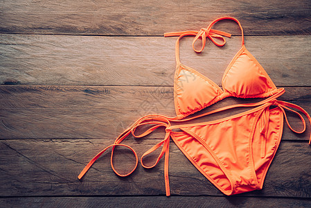 橙色比基尼位于木制地板上     夏末和旅行服女性衣服海洋衬衫杂志拼贴画海滩木头旅行太阳图片