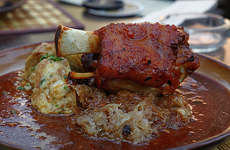 烤猪叉加子的一小片关节酸菜水饺盘子肉质桌子乡村烹饪小腿美食图片