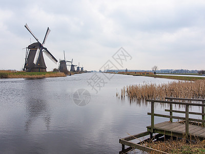荷兰农村风车和运河风车及运河景观堤防小孩农场地标运河旅行天空蓝色绿色乡村图片