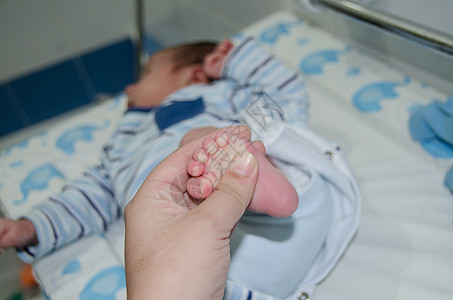 母亲按摩新生儿小婴儿的脚松动脚跟女孩手指按摩师童年父母说谎家庭奶油脚趾图片