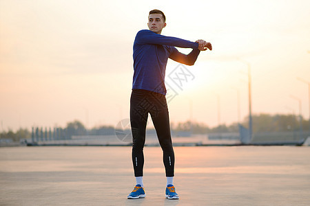 年轻男性赛跑者在日落前伸展 健康生活方式和运动概念晴天训练慢跑者运动员男人公园蓝色闲暇跑步保健图片