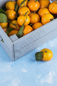 带叶子的盒子里新鲜橘子食物收成礼物水果橙子柑桔果汁热带乡村木头图片