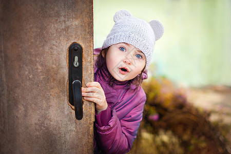 惊喜的可爱的小姑娘打开了门图片
