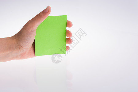 手握着一块纸记事本笔记本空白标签床单卡片矩形办公室笔记黄色图片