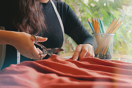 时尚时装设计师裁剪面料的新系列在办公室作坊商业服装裁缝草图工艺女士女性装饰图片