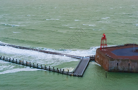 有灯塔和狂野海的码头跳船 海风景 Vlissingen 泽兰 荷兰图片