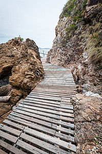 岛上有岩石山谷或悬崖的木环通道途径森林旅行海滩板条远足假期棕色白色木头图片