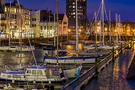 晚上的弗利辛根港有许多停靠的船只 装饰有灯光的船只 有水的灯火通明的城市建筑 荷兰泽兰的热门城市图片