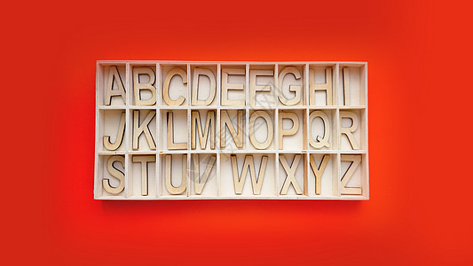 带字母的 Wooden 字母表块 - 红色背景上的框 学习英语图片