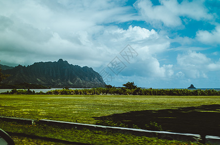 美州夏威夷有美丽的阴云天空和绿地的狂乱山丘图片