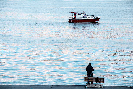 海上渔民和在海水中捕鱼的渔船渔船旅行太阳海滩海岸线钓鱼航海海岸航行运输图片