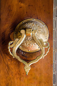 由金属制成的手制托曼门门把手建筑学艺术脚凳门把手木头背景火鸡入口图片