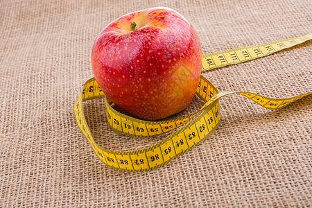 红色苹果 上面有测量磁带仪表重量数字营养食物尺寸饮食损失成功减肥图片