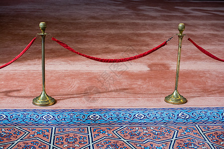 蓝色地毯附近的天鹅绒绳和金属架入口展览贵宾俱乐部博物馆栅栏控制音乐会画廊路障图片