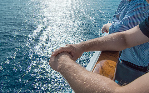 海上巡洋航行的概念 男子在海浪和日落背景下骑着游轮的护航问题上的手甲板旅游享受巡航游艇女士栏杆自由波浪旅行背景图片