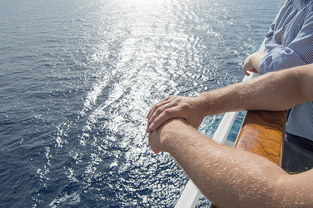 海上巡洋航行的概念 男子在海浪和日落背景下骑着游轮的护航问题上的手自由太阳闲暇旅行旅游游艇男性地平线甲板海洋背景图片