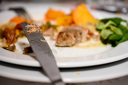 钢刀下一个与部分消费的猪肉牛排同金烤土豆和沙拉相配图片