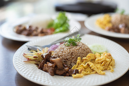 用猪肉和烧鸡蛋在木桌上点燃大米沙拉烧烤牛肉烹饪食物油炸餐厅美食桌子文化图片