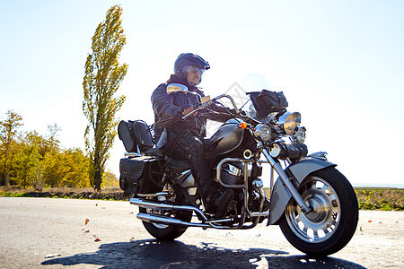 摩托车驾驶员在秋天高速公路上乘坐自定的客车自行车 冒险概念驾驶力量夹克风俗速度旅行叶子自由沥青发动机图片