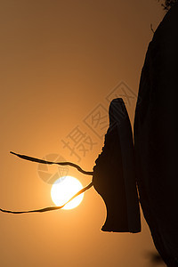 棕色鞋 在山顶日落背景上挂着悬浮的鞋带图片