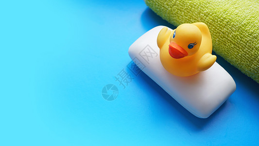蓝色背景的毛巾 肥皂和黄色玩具鸭 平面照片 顶视图乐趣童年海绵卫生小鸭子化妆品酒吧小样气泡婴儿图片